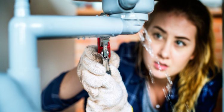 Woman fixing kitchen sink
