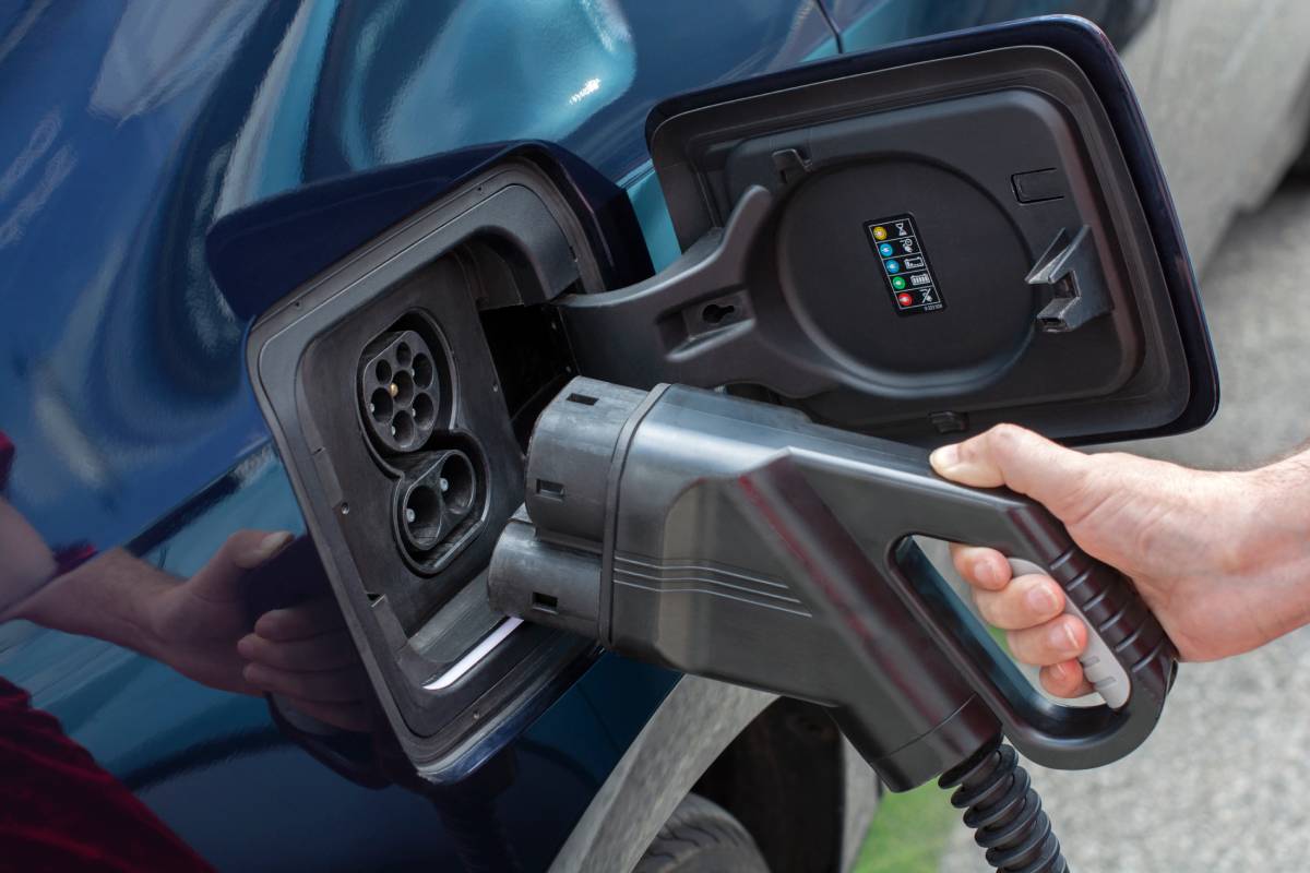 Human hand is holding electric car charging