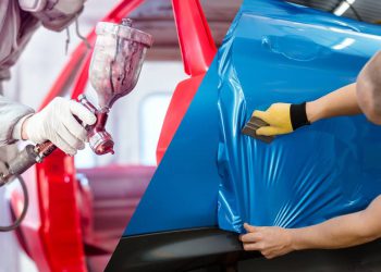 Professional worker spraying red paint on a car body