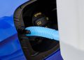 Close up filling of diesel exhaust fluid from canister into the tank of blue car for reduction of air pollution. Environmental or eco friendly solution.