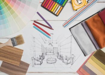 Various interior design materials are scattered on a white wooden surface.